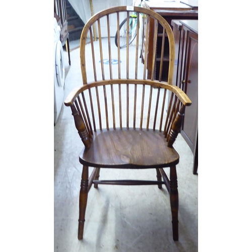 211 - A mid 19thC country made, yew, beech and elm framed, high hoop and spindle back arm chair, the solid... 