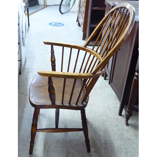 211 - A mid 19thC country made, yew, beech and elm framed, high hoop and spindle back arm chair, the solid... 