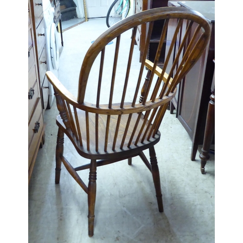 211 - A mid 19thC country made, yew, beech and elm framed, high hoop and spindle back arm chair, the solid... 