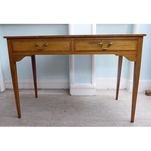 22 - A late 19th/early 20thC mahogany two drawer hall table, raised on square, tapered legs  28