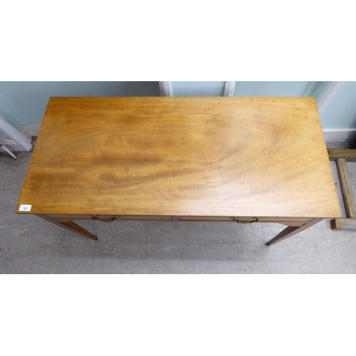 22 - A late 19th/early 20thC mahogany two drawer hall table, raised on square, tapered legs  28