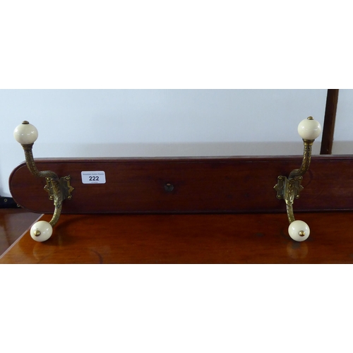 222 - A late Victorian hanging mahogany row of four decoratively cast brass hat and coat hooks with white ... 