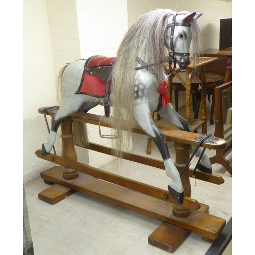 238 - A mid 20thC painted and bridled nursery rocking horse, on a trestle stand  40