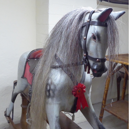 238 - A mid 20thC painted and bridled nursery rocking horse, on a trestle stand  40