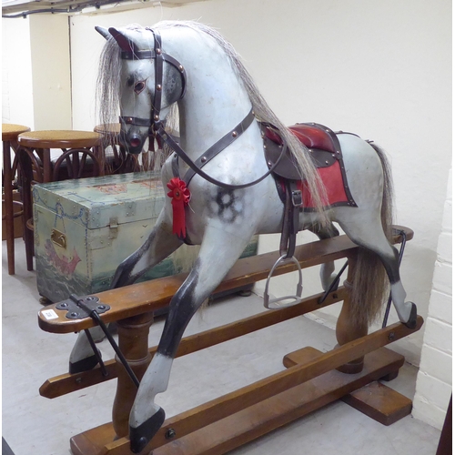 238 - A mid 20thC painted and bridled nursery rocking horse, on a trestle stand  40