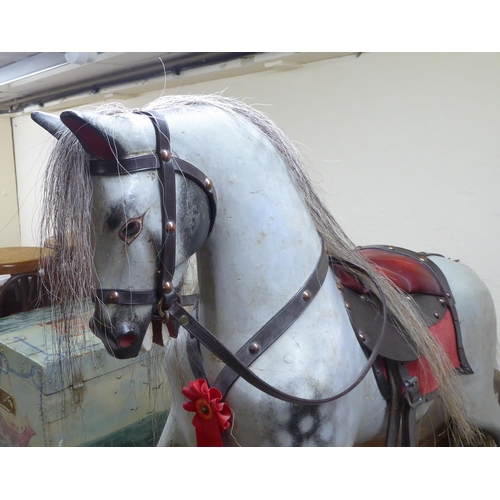 238 - A mid 20thC painted and bridled nursery rocking horse, on a trestle stand  40