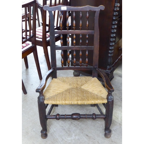 243 - A mid 19thC country made, oak framed Lancashire, high back hall chair with bobbin turned rows, over ... 