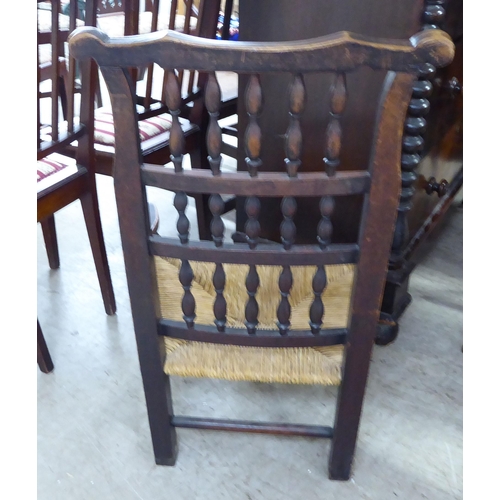 243 - A mid 19thC country made, oak framed Lancashire, high back hall chair with bobbin turned rows, over ... 