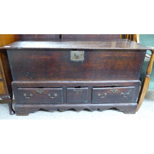 246 - A late 18thC planked oak chest, the hinged top enclosing four small drawers, over a line of three ba... 