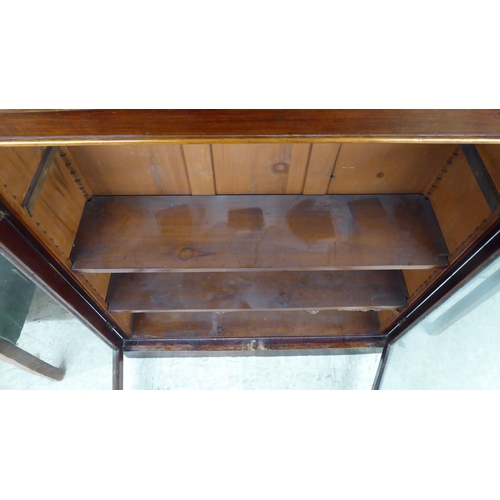 247 - A late Victorian mahogany cupboard, the shelved interior enclosed by a pair of glazed, panelled door... 