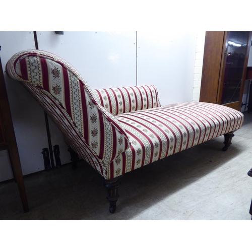 258 - A late Victorian day bed with a pillow back and side, upholstered in striped floral fabric, raised o... 