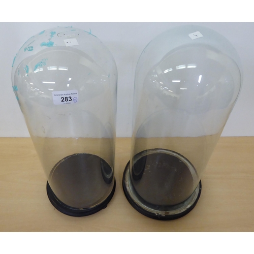 283 - Two glass clock domes, on plinths  19