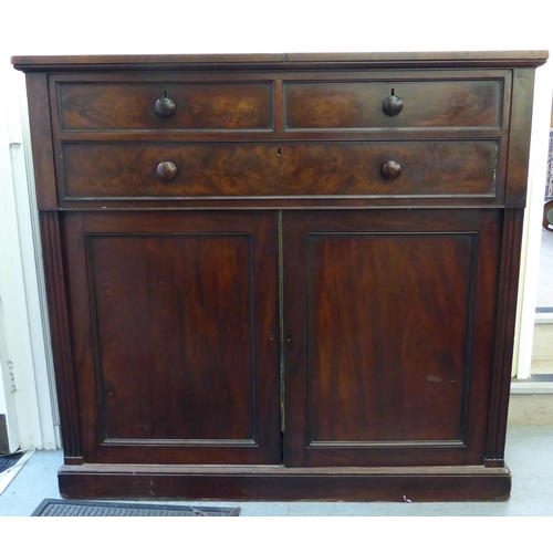 288 - A mid Victorian linen cabinet with two short/one long drawer, over a pair of panelled doors, enclosi... 