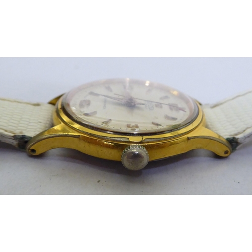 293 - A Roma gold plated, manual wind wristwatch, faced by a baton dial, on a white leather strap