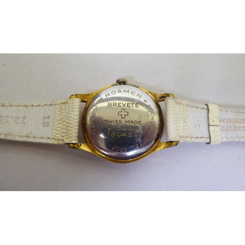 293 - A Roma gold plated, manual wind wristwatch, faced by a baton dial, on a white leather strap