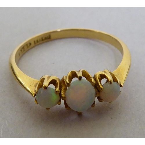 298 - An 18ct gold three stone opal ring