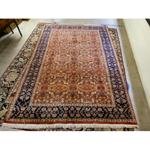 30 - A Persian rug, decorated with small flower head designs and a border, on a multi-coloured ground&nbs... 