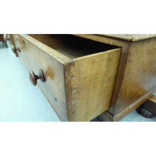 301 - A late 19thC oak cupboard with a pair of panelled doors, enclosing a shelved interior, over two draw... 