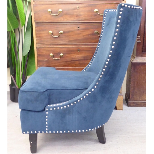 303 - A modern stud upholstered, blue fabric bedroom chair, raised on square, tapered legs