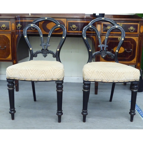 305 - A pair of late Victorian, ebonised framed and gilt, button effect chairs with later fabric upholster... 