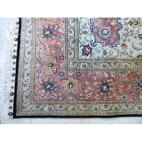 320 - An Asian part silk woven rug, decorated with floral designs, in a multitude of colours, on a black c... 