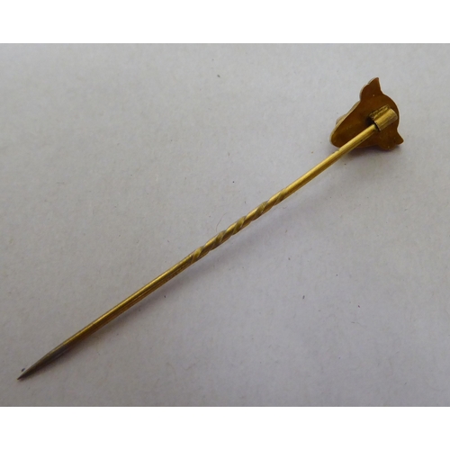 326 - A 9ct gold pin brooch, the finial fashioned as a bull's head, set with ruby eyes