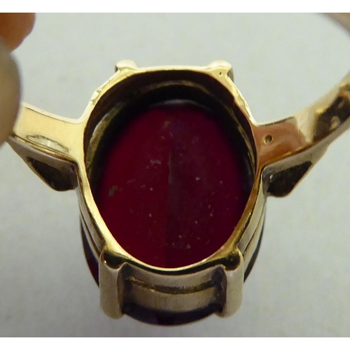 327 - A 9ct gold ring, set with a red stone