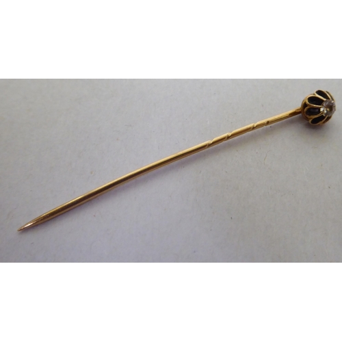 331 - A yellow metal scarf pin, set with a diamond