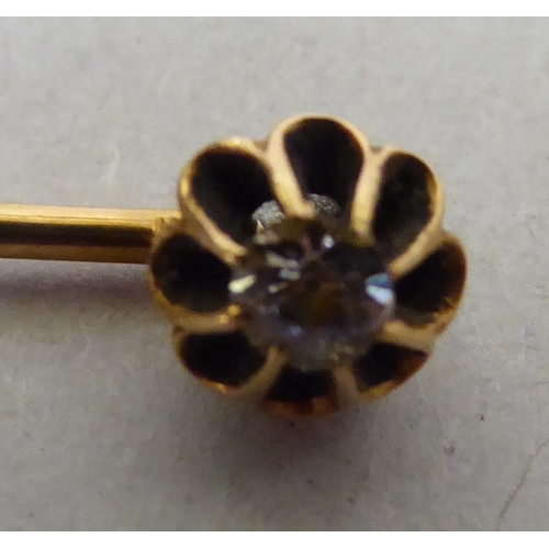 331 - A yellow metal scarf pin, set with a diamond