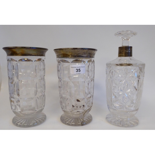 35 - A mixed lot: to include a pair of lead crystal vases, each with a silver collar  London 1922  7.5