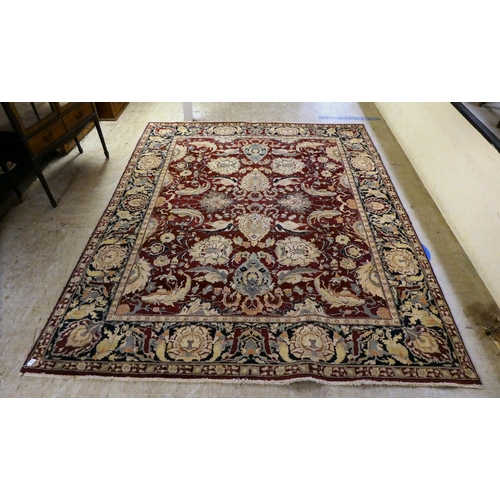 56 - A Persian rug, decorated with stylised flora and foliage designs, on a multi-coloured ground  98