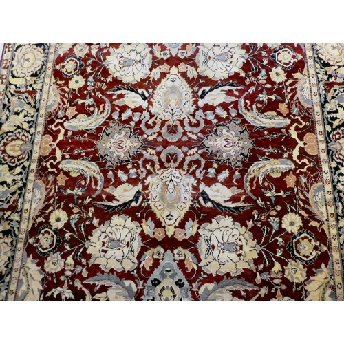 56 - A Persian rug, decorated with stylised flora and foliage designs, on a multi-coloured ground  98