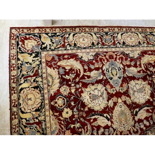 56 - A Persian rug, decorated with stylised flora and foliage designs, on a multi-coloured ground  98