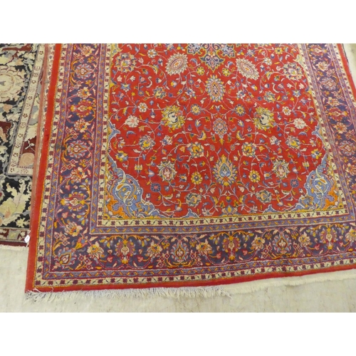 60 - A Central Persian rug, decorated with floral designs, on a mainly red ground  90