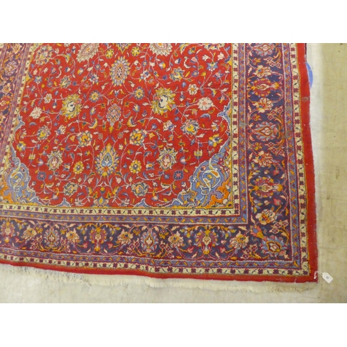 60 - A Central Persian rug, decorated with floral designs, on a mainly red ground  90