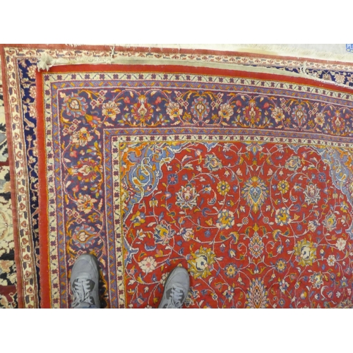 60 - A Central Persian rug, decorated with floral designs, on a mainly red ground  90