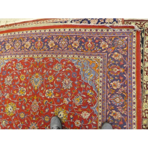 60 - A Central Persian rug, decorated with floral designs, on a mainly red ground  90