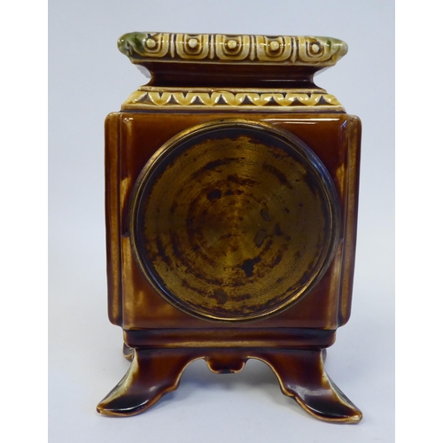 89 - An early 20thC Continental foliate moulded china, square cased mantel timepiece; faced by a brass an... 