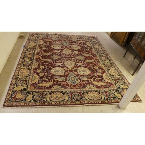 56 - A Persian rug, decorated with stylised flora and foliage designs, on a multi-coloured ground  98