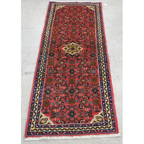 106 - A Persian design runner, decorated with floral motifs, on a red ground  78