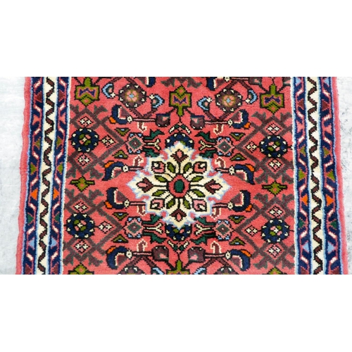 106 - A Persian design runner, decorated with floral motifs, on a red ground  78