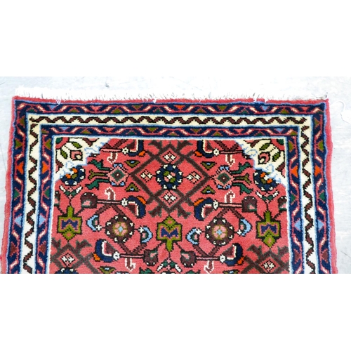 106 - A Persian design runner, decorated with floral motifs, on a red ground  78