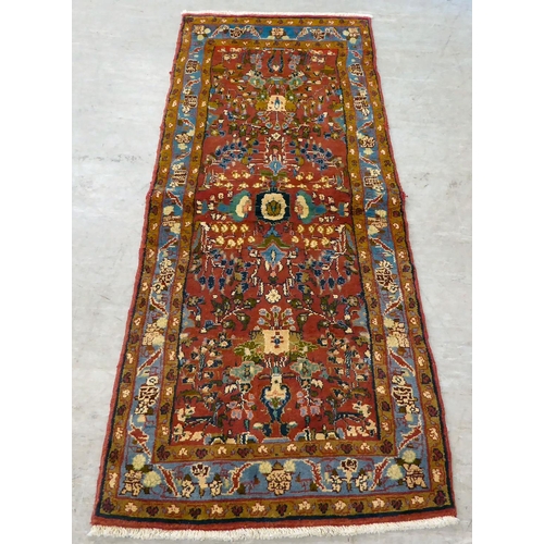 111 - A Persian design rug, decorated and bordered with floral motifs, on a red ground  78