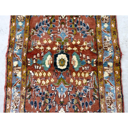 111 - A Persian design rug, decorated and bordered with floral motifs, on a red ground  78