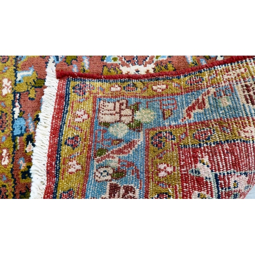 111 - A Persian design rug, decorated and bordered with floral motifs, on a red ground  78