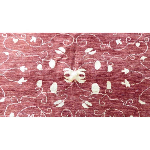 116 - A Ziegler design rug, decorated with trailing floral patterns, on a red ground  71