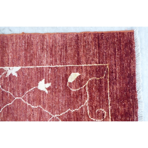 116 - A Ziegler design rug, decorated with trailing floral patterns, on a red ground  71