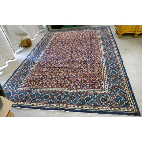 121 - A Persian design carpet, decorated and bordered with repeating geometric patterns, on a blue ground&... 