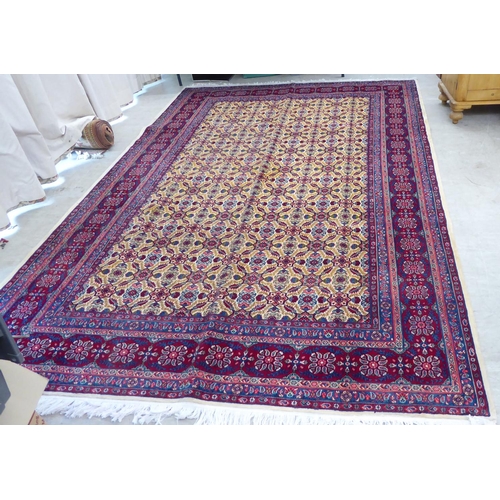 126 - A Persian design carpet, decorated with repeating floral patterns, on a red ground  126