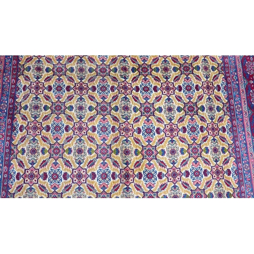 126 - A Persian design carpet, decorated with repeating floral patterns, on a red ground  126